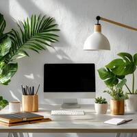 A desk with a computer, laptop, and plants photo
