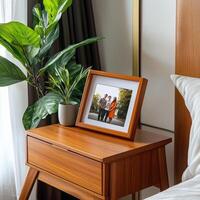 A wooden nightstand with a picture frame on it photo
