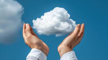 Hands holding up a cloud in front of a blue sky photo