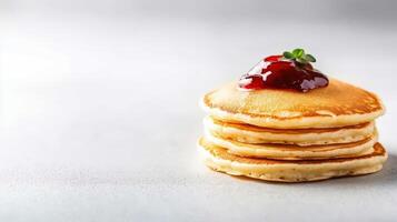 Stack of pancakes with strawberry jam on top photo
