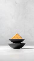 A stack of two black bowls on a white table photo