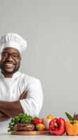 Chef with arms crossed and smiling with vegetables and meat photo
