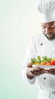 A chef holding a plate with vegetables photo
