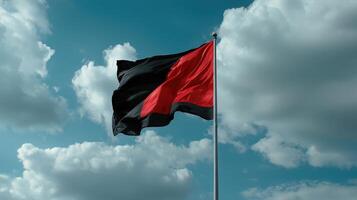 A red and black flag flying in the wind photo