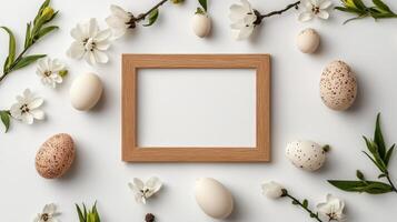 Easter eggs and flowers around a wooden frame on a white background photo