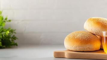 Bread rolls and a glass of tea on a wooden cutting board photo
