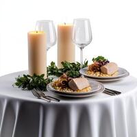 A table with two plates of food and two candles photo