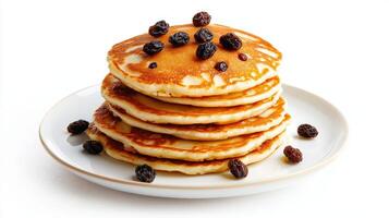 A stack of pancakes with raisins on top photo