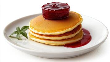 A stack of pancakes with syrup and jam photo