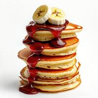 A stack of pancakes with syrup and bananas photo