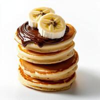 A stack of pancakes topped with chocolate and bananas photo