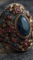 Intricate antique ring features deep blue gemstone and colorful accents in ornate metalwork photo