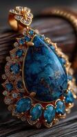 Beautiful blue gemstone pendant with intricate gold detailing on a wooden surface photo