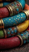 Colorful handmade bracelets made with intricate designs and vibrant materials displayed on a textured surface photo