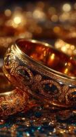 Elegant gold rings showcased with intricate designs on a sparkling surface in a soft light setting photo