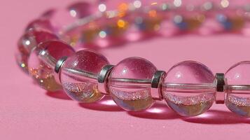 Elegant pink crystal bead necklace displayed on a vibrant pink background, showcasing its intricate design and shine during daylight photo