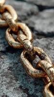 Close-up view of a rusty gold chain resting on a textured stone surface under natural light photo