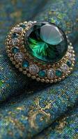 Exquisite green gemstone brooch resting on intricately patterned fabric showcasing craftsmanship and elegance photo