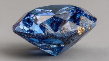 Blue gemstone showcasing intricate facets with natural inclusions shining under soft light in a neutral backdrop photo