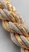 Shiny golden and silver braided rope twisted intricately under soft light photo
