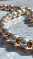 Elegant pearl necklace with golden accents on a marble surface in bright sunlight photo