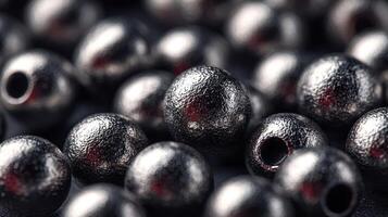 Close-up view of shiny metallic beads arranged on a dark surface showcasing texture and reflections photo