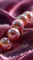 Pink pearls arranged elegantly on soft fabric with water droplets sparkling in light photo