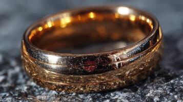 Elegant gold wedding band resting on textured surface, showcasing intricate details and reflections during daylight photo