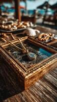 Beautiful golden pendant placed within an ornate frame on a wooden table near the beach at sunset photo