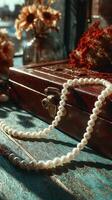 Elegant string of pearls draped over vintage jewelry box in warm afternoon light photo