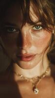 Portrait of a young woman with freckles and long hair in golden light, showcasing natural beauty and subtle jewelry photo