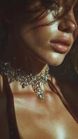 Close-up of a woman showcasing an elegant necklace and glowing skin with dramatic lighting in a softly lit environment photo