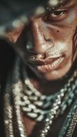 Close-up view of a young man with intense expression adorned in chains in an urban setting during golden hour photo