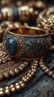 Intricately designed gold jewelry with dark stone showcased on a rustic wooden surface photo