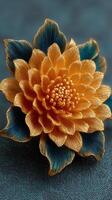 Intricate golden flower design with blue leaves on textured background in handcrafted art photo