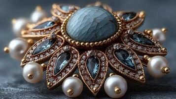 Elegant antique brooch with intricate design featuring gemstones and pearls on a dark textured surface photo