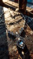 Elegant silver necklace with sparkling crystals showcased on rustic wooden surface in soft sunlight photo