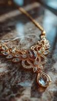 Elegant gold jewelry necklace with sparkling gemstones displayed on marble surface photo