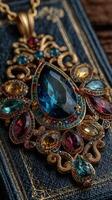 Intricately designed vintage pendant with colorful gemstones displayed on a decorative book photo