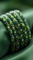 Beautiful green beaded bracelet showcasing intricate craftsmanship on a rich green fabric backdrop photo