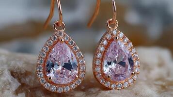 Elegant rose gold earrings with sparkling pink gemstones displayed on a textured surface at a close angle during daylight photo