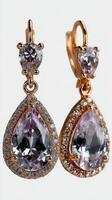 Elegant tear-shaped earrings featuring sparkling gemstones and intricate detailing in a gold setting photo