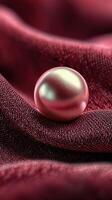 Elegant pink pearl resting on luxurious burgundy fabric at a serene setting photo