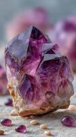 Natural amethyst crystal cluster resting on soft sandy surface with sparkling smaller stones around it photo