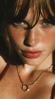 Young woman with freckled skin and wet lips poses closely in warm sunlight during summer afternoon photo