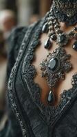Elegant black lace gown with intricate silver jewelry displayed in a vintage setting photo