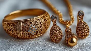 Elegant gold jewelry set displayed on delicate fabric with intricate designs and sparkling details, showcasing craftsmanship and artistry photo