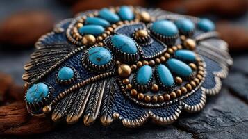 Intricate turquoise jewelry piece displayed on textured surface with natural elements highlighting craftsmanship and design details photo