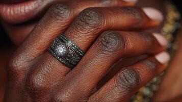 Elegant black ring sparkles on the hand in a close-up shot showcasing detailed craftsmanship and skin texture photo