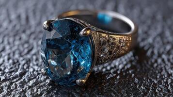 Beautiful blue gemstone ring placed on textured black surface showcasing its intricate design and sparkle photo
